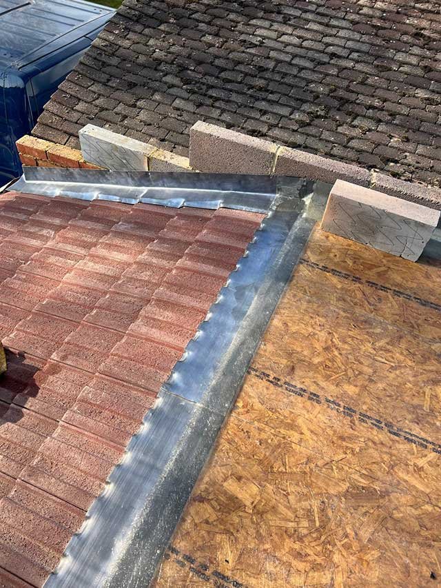 Red roof tiles and fresh lead work